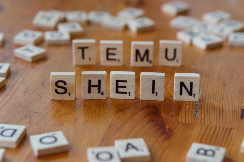 scrabble tiles spelling temu shein on wooden table