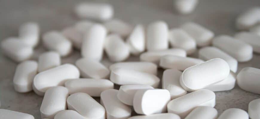 white medication pills on brown surface