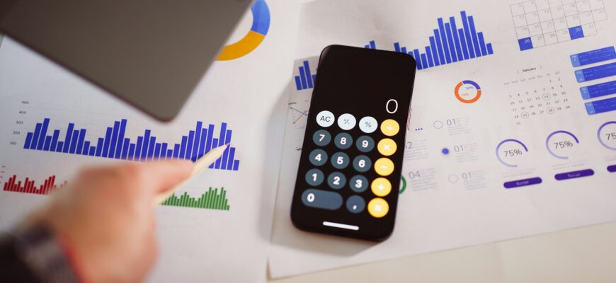 a calculator sitting on top of a table next to a laptop