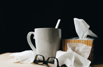 white ceramic mug on white table beside black eyeglasses