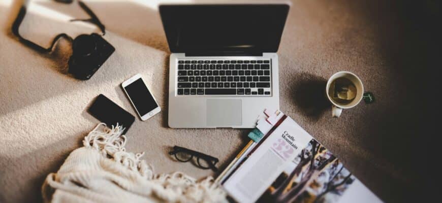 white ceramic mug near MacBook Pro