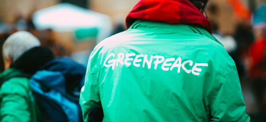 man in green hoodie walking on street during daytime