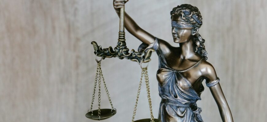 woman holding sword statue during daytime