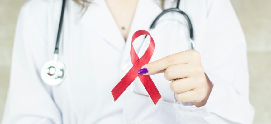 a woman in a white shirt holding a red ribbon