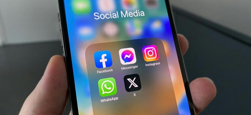 a person holding a cell phone with social media on the screen