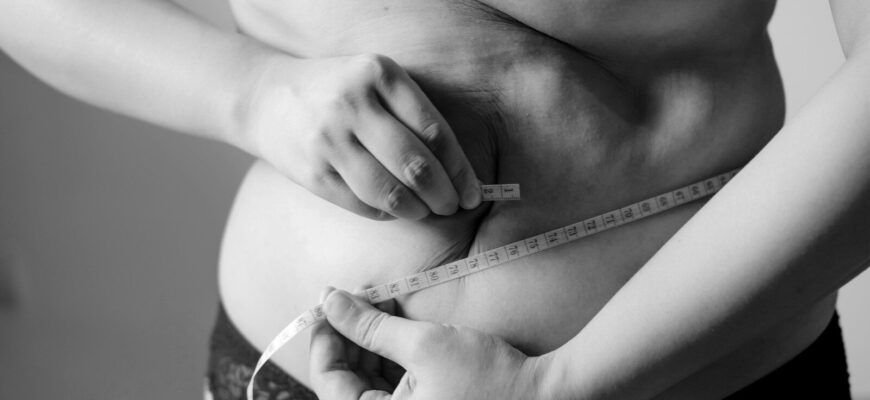 grayscale photo of woman holding her breast