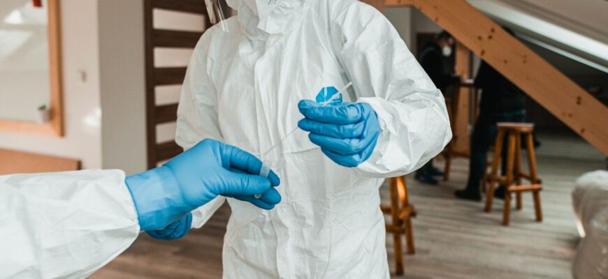 a person in a white suit and blue gloves