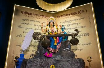 Goddess saraswati statue holding a veena with a peacock.