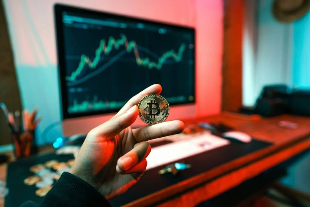 Tânăr de 20 de ani, înșelat cu 90.000 de lei sub pretextul unui schimb de criptovalută. Trei persoane au fost reținute 1 a person holding a coin in front of a computer