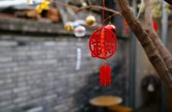 a red chinese style wind chime hanging from a tree