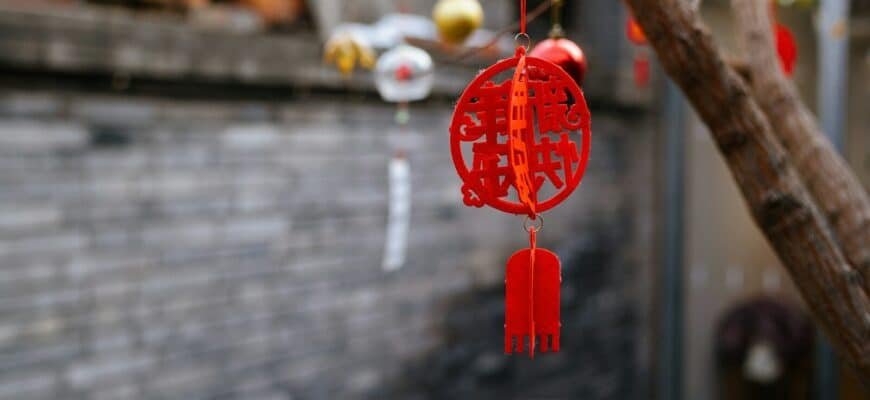 a red chinese style wind chime hanging from a tree